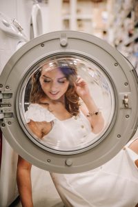 Model sitting behind a washer door in Lowes appliance section