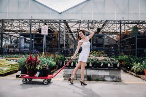 Model pulling a cart with potted plants at Lowes