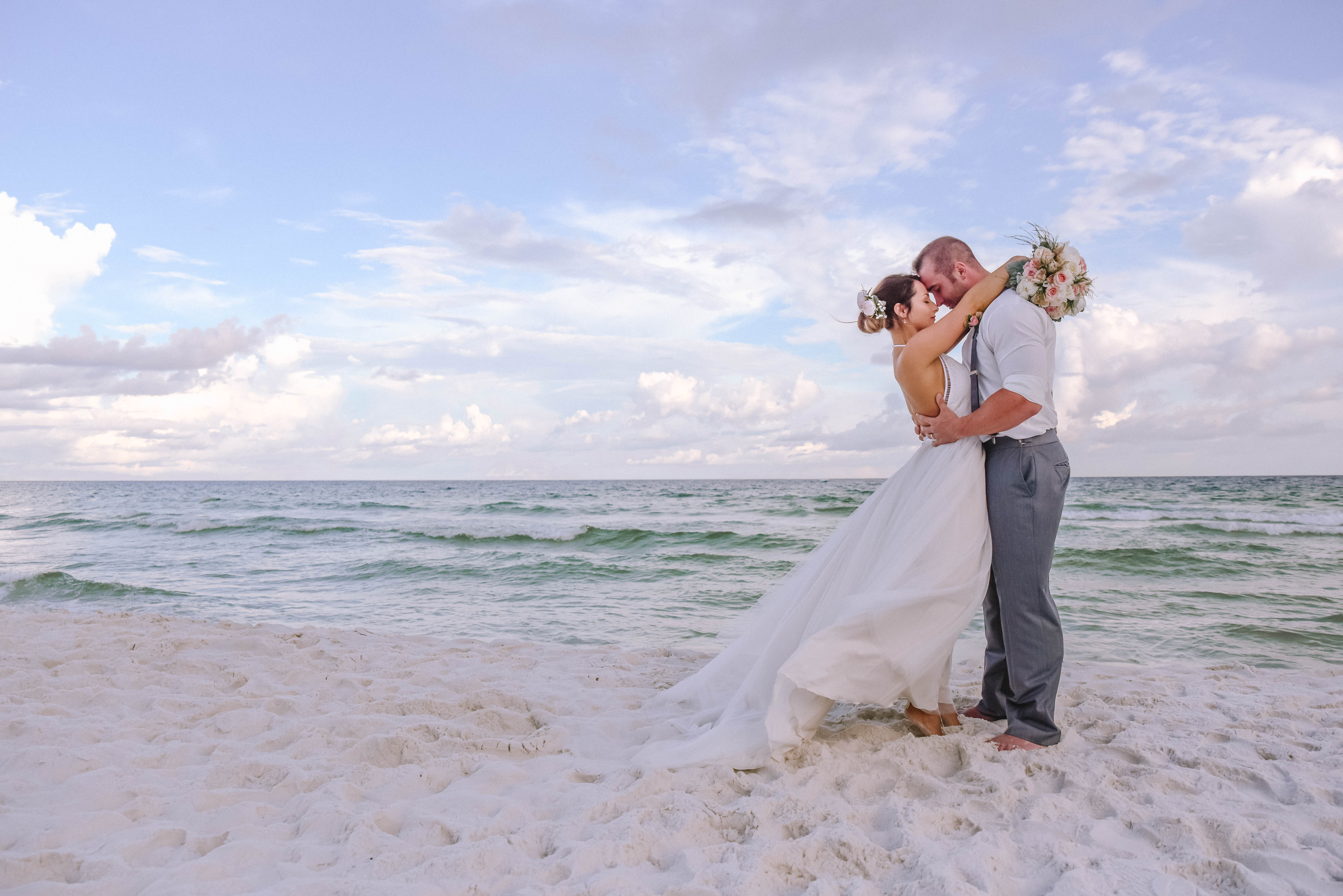 Newlyweds standing on the Destin, Florida white sand beaches