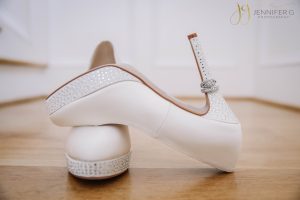 Detail photo of weddings rings and brides heels.