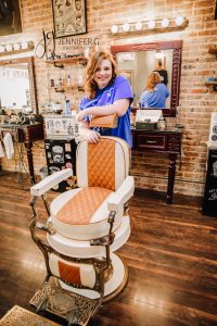 High school senior posing with barber chair at Hub City Barbers located in Crestview, Florida.