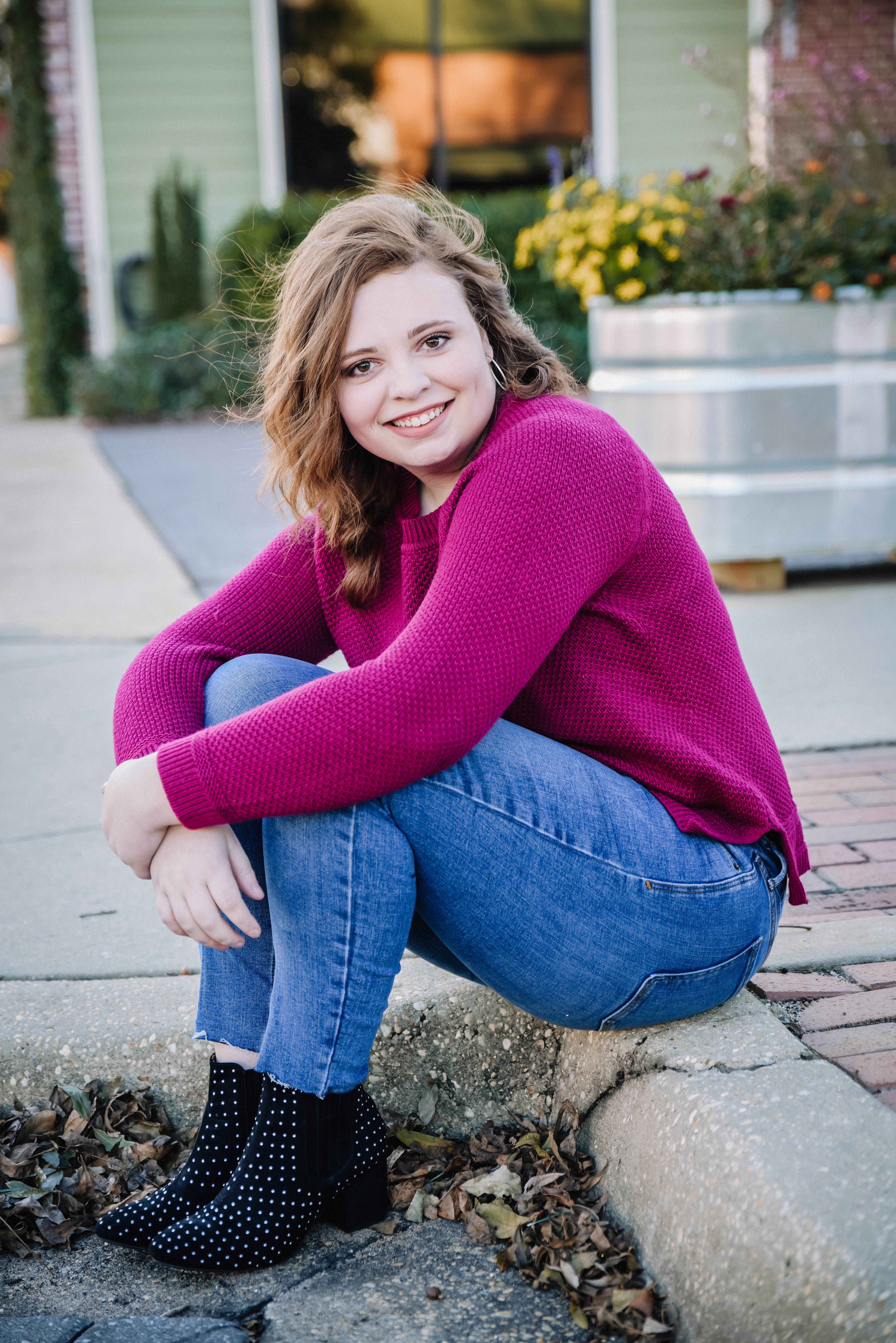High school senior sitting on a curb in downtown located in Crestview, Florida.