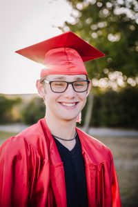 High School Senior smiling with his cap and gown