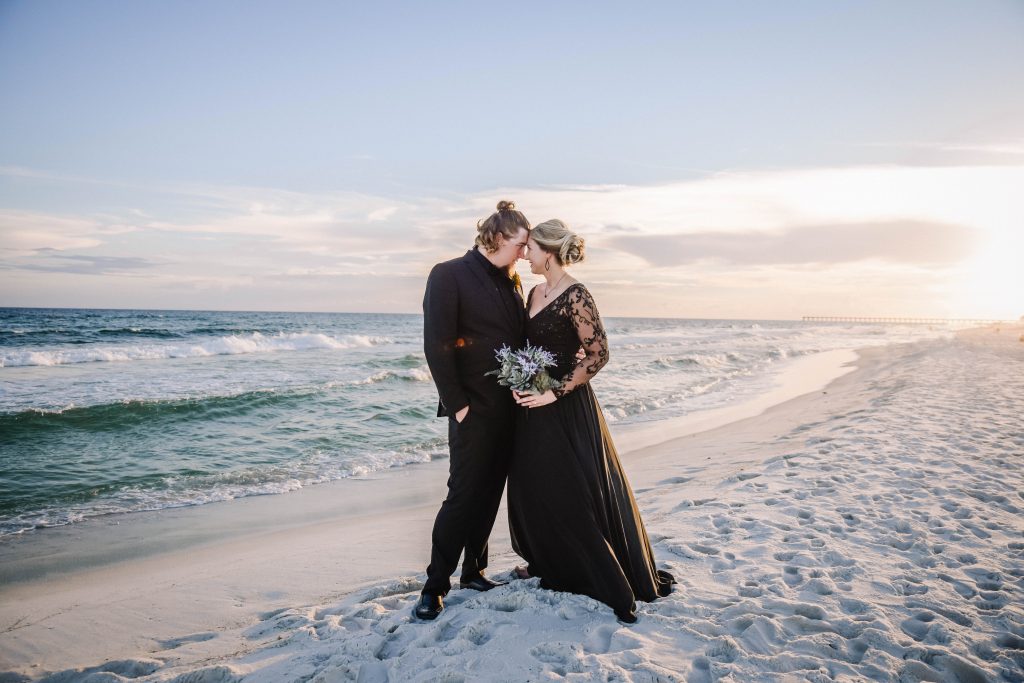 Bride and groom holding each other on the beach during sunset