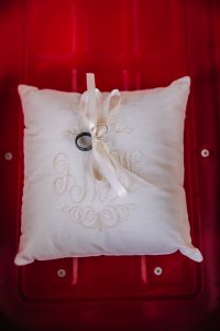 Detail photo of wedding rings tied on ring bearer pillow.