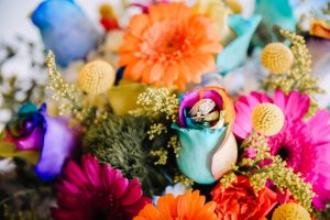 Wedding rings nestled in a colorful wedding bouquet in Navarre Florida.