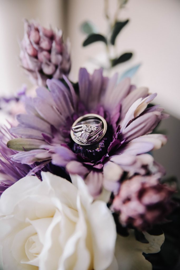 Wedding rings sitting in a lavender bridal bouquet