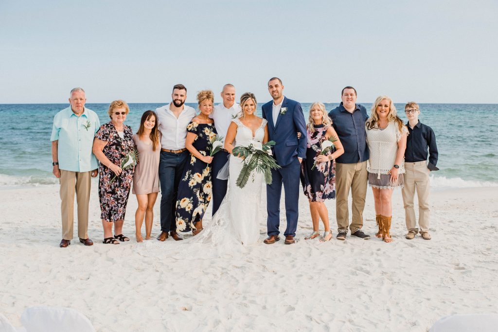 Group picture of the bride and grooms family on the beach during their destination wedding in Navarre Beach, Florida.