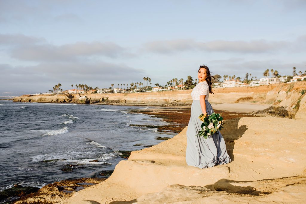 Bride holding a beautiful bouquet at Sunset Cliffs in San Diego, CA for her 10 year vow renewal